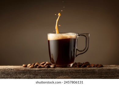 Espresso coffee glass cup with splashes on a brown background. Coffee cup and roasted coffee beans on a old wooden board. - Powered by Shutterstock