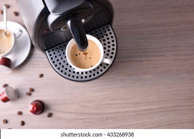 Espresso coffee machine with capsules and coffee served background on wood table. Top view