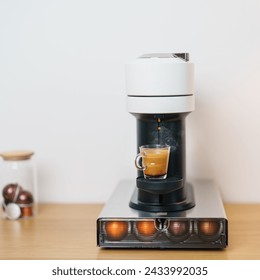 Máquina de café expreso con cápsula de grano de café tostado en barra de mesa de madera. Bebida diaria en el hogar, apartamento y concepto de oficina