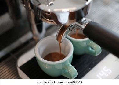 Espresso Extraction By Professional Espresso Machine At Coffee Shop. Espresso Pour Into The Green Cup On The Scales.