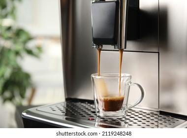 Espresso machine pouring coffee into glass cup against blurred background, closeup. Space for text - Powered by Shutterstock