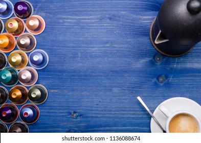 espresso, espresso maker and coffee capsules on a blue wooden background