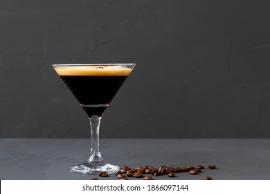 Espresso Martini Cocktail Garnished With Coffee Beans On Table. Martini Glass With Brown Coffee Beans On A Black Background. Alcohol Drinks. Copy Space