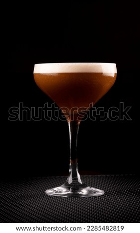 espresso martini cocktail in glass served under rubber holder