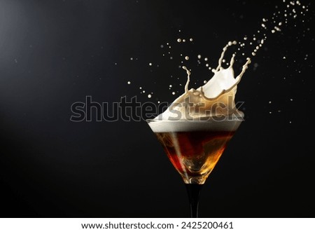 Espresso Martini drink with splashes on a black background. Copy space.