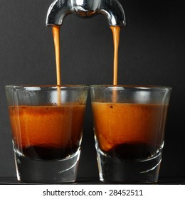 Espresso Pouring Into Two Shot Glasses