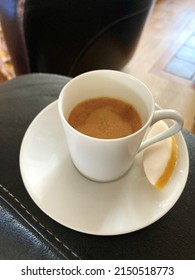 Espresso served in a white cup of coffee with one calisson.