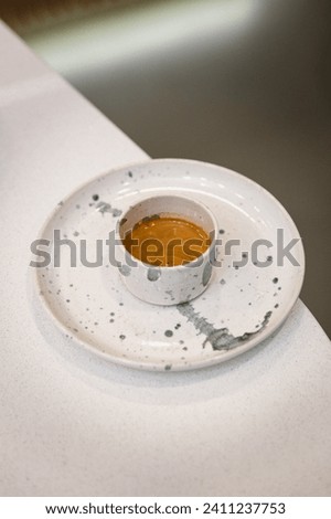 Espresso shot in a small ceramic mug served on plate