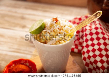 Esquites. Corn kernels cooked and served with mayo, sour cream, lemon and chili powder, very popular street food in Mexico, also known as Elote en Vaso. The recipe varies depending on the region.