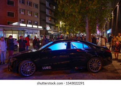 ESSEN, GERMANY - 26 OCTOBER 2019: Night Scenery Of People Interest In Outdoor Lighting Installation Art And Video Mapping Inside Car For Essen Festival Of Light In Essen, Germany.