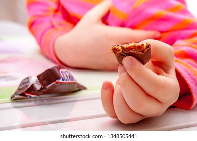 ESSEN / GERMANY - FEBRUARY 02 2019 : Little Girl Eating Snickers Chocolate Bar.