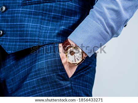 Essential accessory in any menswear collection. Luxury watch worn on male wrist. Classic timepiece. Fashion accessory. Trendy style. Punctuality and promptness. Current time.