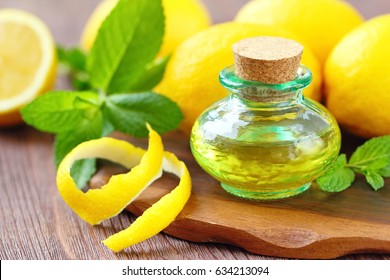 Essential aroma oil with mint and lemon on wooden background