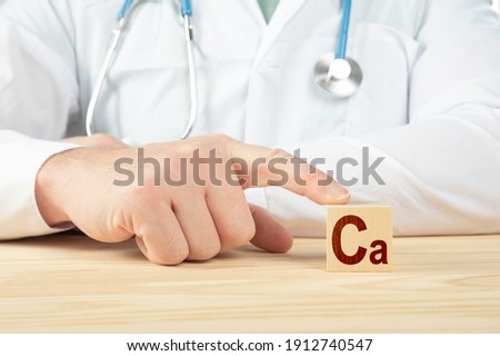 essential element and minerals for humans. doctor recommends taking calcium. doctor talks about the benefits of calcium. calcium - Health Concept. Ca alphabet on wood cube.