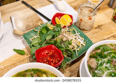 Essential Fresh Ingredients for Vietnamese Pho: Basil, Bean Sprouts, Lime, and Pickles to Enhance the Flavorful Broth - Powered by Shutterstock