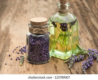 essential lavender oil, herbal soap and bath salt with fresh flowers on wooden background. selective focus