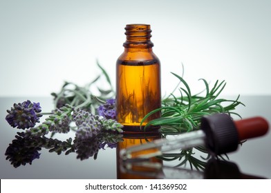 Essential oil bottle with rosemary and lavender flowers
