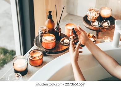 Essential oil bottle standing at beautiful hot tub bath with candles. Beauty and spa concept.  - Powered by Shutterstock