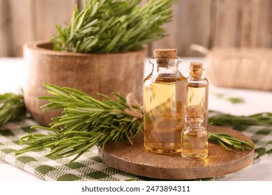 Essential oil in bottles and rosemary on table