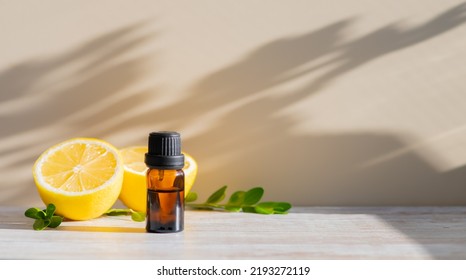 Essential oil in brown bottle and cut lemon on a background - Shutterstock ID 2193272119