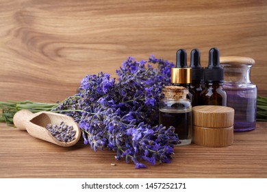 essential oil and lavender flowers on wooden table