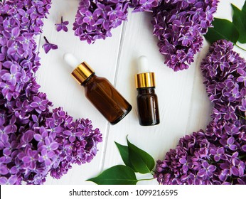 Essential oil with lilac flowers on a old wooden background