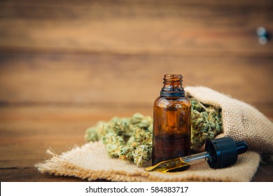 Essential oil made from medicinal cannabis. Buds. Skunk. Marijuana on wooden background 