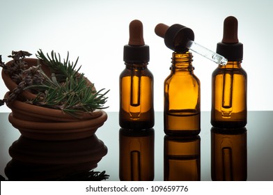 essential oil with rosemary and lavender flowers