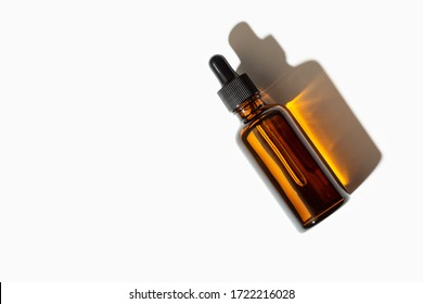 Essential oil or serum glass bottle with pipette isolated on white background. Copy space