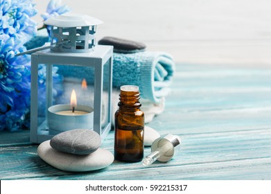 Grundlegende Heilbehandlung. Blaue Blumen, Kieselsteine und Kerzenlicht auf Holzhintergrund. 