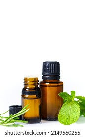 Essential Oils In Dark Glass Bottle With Aroma Herbs. Aromatherapy Concept. Fresh Leaves Of  Peppermint And Rosemary Closeup To Jars On White Background, No People, Selective Focus