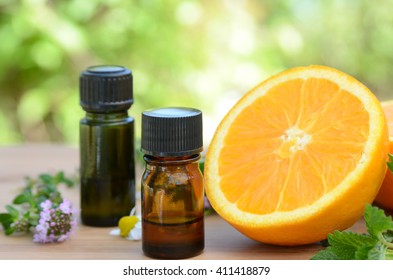 Essential Oils With Orange And Herbs In Garden Spa