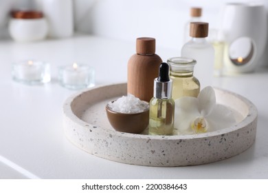 Essential oils, sea salt and orchid flower on white table in bathroom, closeup. Space for text - Shutterstock ID 2200384643