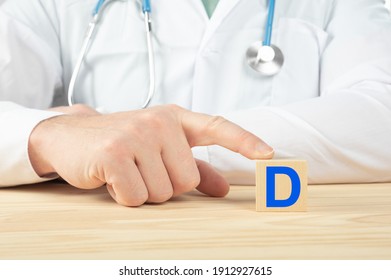 essential vitamins and minerals for humans. doctor recommends taking vitamin D. doctor talks about the benefits of vitamin D. D Vitamin - Health Concept. D alphabet on wood cube.