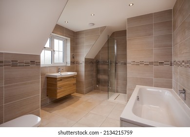 Essex, England - September 7 2016:  Brand New Modern Luxury Bathroom With Walk In Shower And Tiled Walls, Heated Towel Rail And Bath Tub.