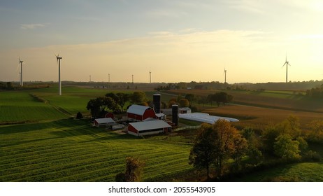 Establishing Shot, Aerial Of Family Farm In United States, Wind Turbines, Barn And Fields In Sunset Light. Rural Midwest, Overhead Shot. Autumn Fall Season, October