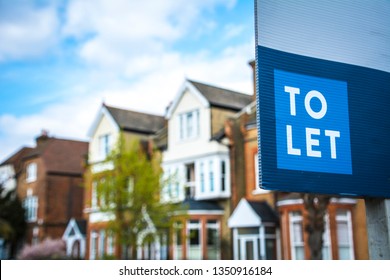 Estate agency 'To Let' sign board with large typical British houses in the background - Shutterstock ID 1350916184