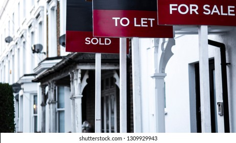 Estate agent  'for sale', 'to let' and 'sold' signage boards of street of terraced houses