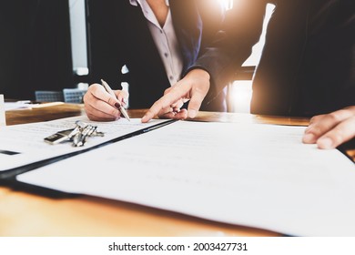 estate agent gives pen and documents agreement with customer to sign contract. Concept agreement. - Shutterstock ID 2003427731