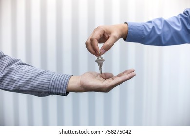 Estate Agent Giving House Keys To Man In Office