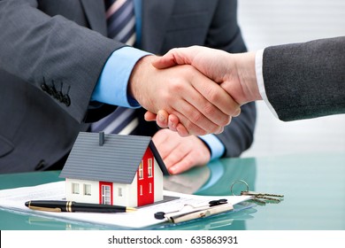 Estate-Agent schüttelt dem Kunden nach Vertragsunterzeichnung die Hand