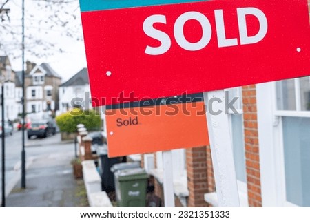 Estate agent 'SOLD' sign on residential street