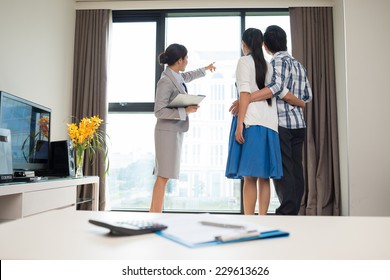 Estate Broker Showing Married Couple The View From The Apartment Window