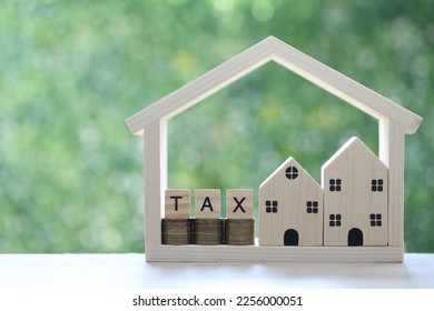 Estate tax,Model house with stack of coins money and tax word on green background,Business investment and Property tax concept - Shutterstock ID 2256000051