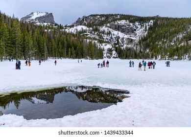 Estes Park, Colorado, USA - April 20, 2019: It's Spring Time; Tourists Are Enjoying On The Still Frozen And Snow-covered Bear Lake In Rocky Mountain National Park.