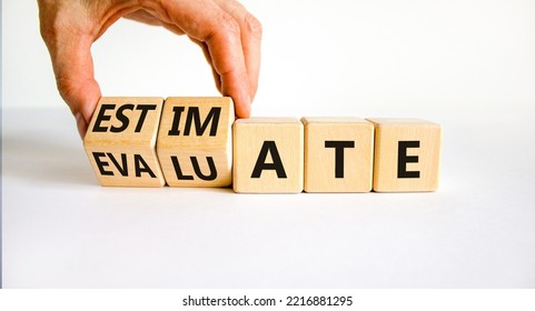 Estimate Or Evaluate Symbol. Businessman Turns Wooden Cubes And Changes The Word 'evaluate' To 'estimate'. Beautiful White Background, Copy Space. Business, Estimate Or Evaluate Concept.