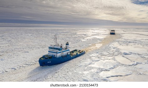 Pärnu, Estonia - 27.02.2022: Aerial View To The Ice Breaker Assisting Cargo Ship To Reach The Harbor Via Waterway Through  The Frozen Sea Bay