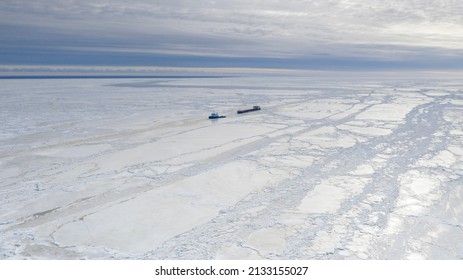 Pärnu, Estonia - 27.02.2022: Aerial View To The Ice Breaker Assisting Cargo Ship To Reach The Harbor Via Waterway Through  The Frozen Sea Bay