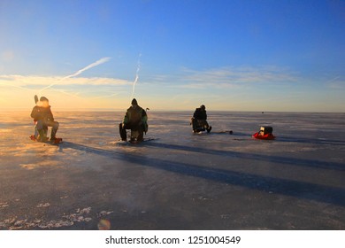 Pärnu, Estonia,  February 17, 2017: Ice Fishing Anglers On Ice And Beautiful Yellow Sunset In Pärnu Bay, Baltic Sea, Estonia