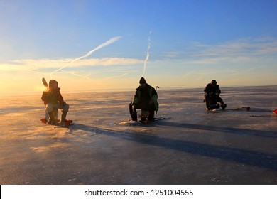 Pärnu, Estonia,  February 17, 2017: Ice Fishing Anglers On Ice And Beautiful Yellow Sunset In Pärnu Bay, Baltic Sea, Estonia